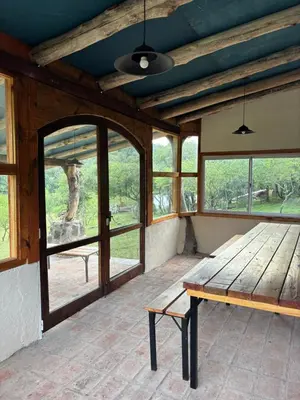 an empty porch with a wooden bench and windows at Rio Dorado Resort in Cavalango