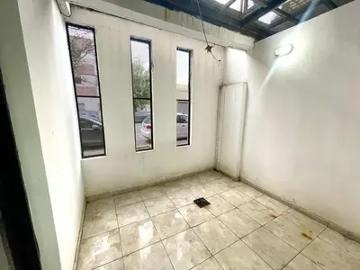 an empty room with three windows and a tiled floor at Rincon de Alta Cordoba in Cordoba