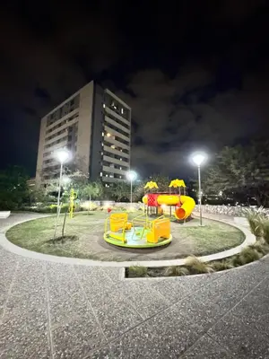 a park at night with a yellow playground at Departamento Temporario en Cordoba Capital in Cordoba