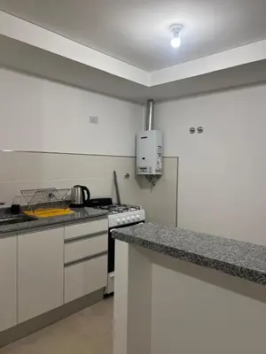 a kitchen with white cabinets and a counter top at Departamento Temporario en Cordoba Capital in Cordoba