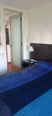 a bedroom with a large bed with a blue blanket at Dpto Nueva Cordoba frente Palacio Ferreyra a 100mt Consulado España in Cordoba
