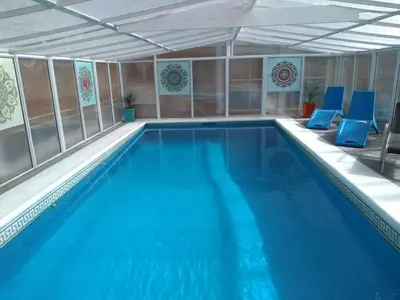 a swimming pool with blue chairs in a building at Cabañas Pio Pio in Merlo