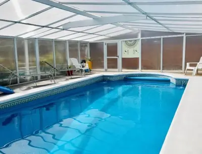 a large swimming pool with blue water in a building at Cabañas Pio Pio in Merlo