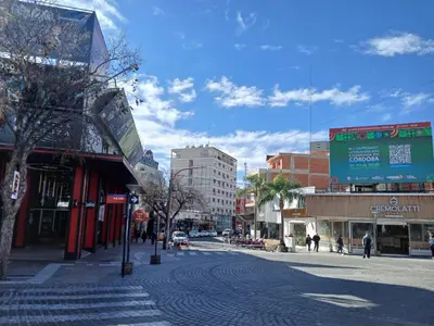a city street with buildings on a sunny day at Departamento Monoambiente Centro Villa Carlos Paz in Villa Carlos Paz