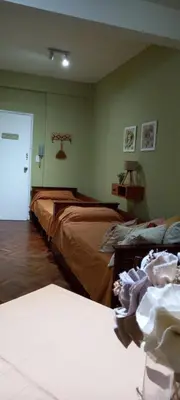 a bedroom with two beds and a door to a room at Departamento Monoambiente Centro Villa Carlos Paz in Villa Carlos Paz