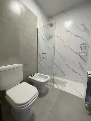 a bathroom with a toilet and a shower and a sink at Depto Paseo Quattro in Villa Carlos Paz