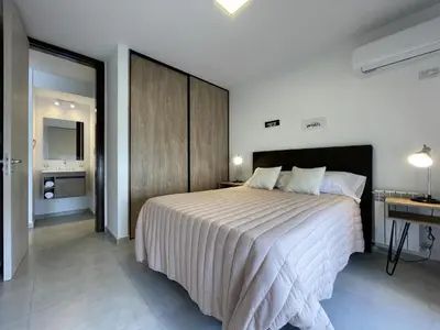 a bedroom with a large bed and a desk at Depto Paseo Quattro in Villa Carlos Paz
