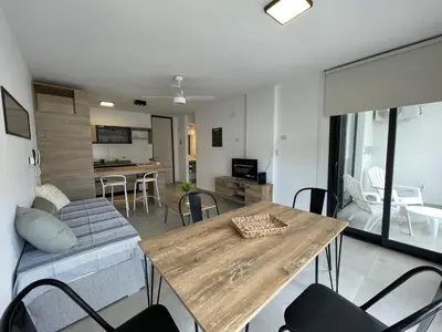 a living room with a wooden table and chairs at Depto Paseo Quattro in Villa Carlos Paz