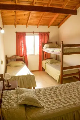a bedroom with three bunk beds and a window at Cabañas del Bosque in Merlo