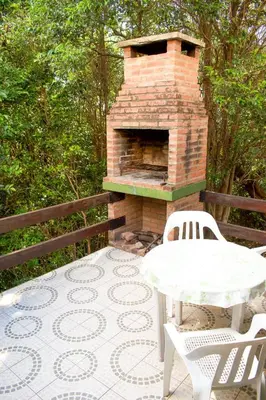 a brick oven with a table and chairs on a patio at Cabañas del Bosque in Merlo