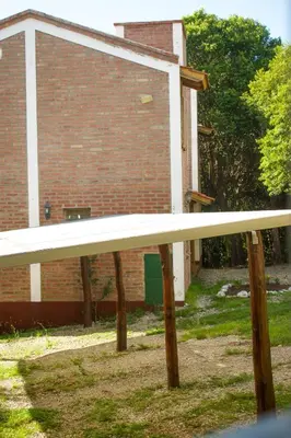 a white bench in front of a brick building at Cabañas del Bosque in Merlo