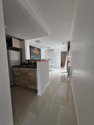 a white kitchen with a counter in a room at Agradable departamento in Cordoba
