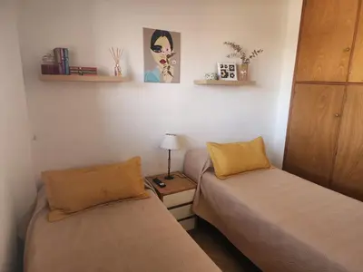 a room with two beds and a lamp on a table at FANTASTICO departamento en el CENTRO DE CARLOS PAZ in Villa Carlos Paz