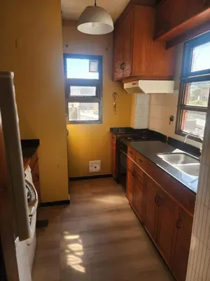 a small kitchen with wooden cabinets and a sink at FANTASTICO departamento en el CENTRO DE CARLOS PAZ in Villa Carlos Paz