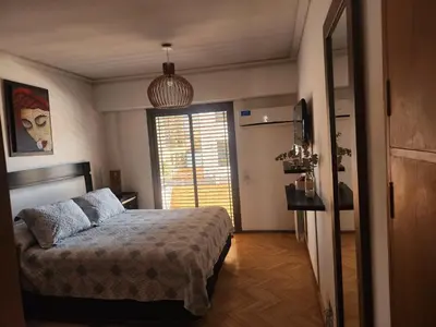 a bedroom with a bed and a large window at FANTASTICO departamento en el CENTRO DE CARLOS PAZ in Villa Carlos Paz
