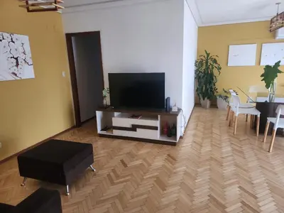 a living room with a flat screen tv and a table at FANTASTICO departamento en el CENTRO DE CARLOS PAZ in Villa Carlos Paz