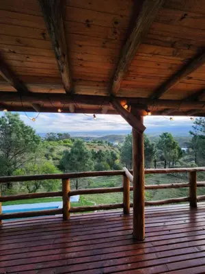 a view from the deck of a wooden house at Cabaña La Lechuza in Villa Ciudad de America