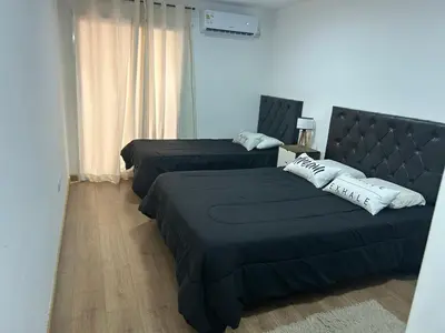 a bedroom with two beds and a headboard at Depto Balcones Cofico 4 in Cordoba