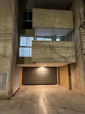 an empty parking garage with a garage door and a building at Depto Balcones Cofico 4 in Cordoba