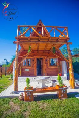 a log cabin with a bench in the grass at Cabaña Yael in Villa Parque Siquiman