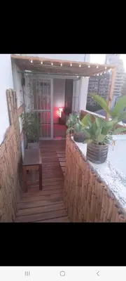 a porch with a bench and potted plants on it at Derpa zion in Cordoba