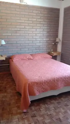 a bedroom with a bed with a brick wall at Tierra Mia in Carpintería