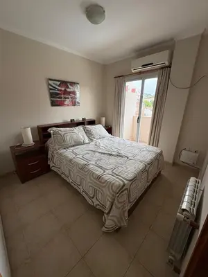 a bedroom with a large bed and a window at Dpto Centrico Carlos Paz in Villa Carlos Paz