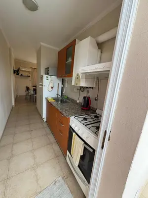 a small kitchen with a stove and a refrigerator at Dpto Centrico Carlos Paz in Villa Carlos Paz
