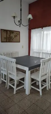 a dining room table with white chairs around it at DEPARTAMENTO CORDOBA Capital ZONA NORTE in Cordoba