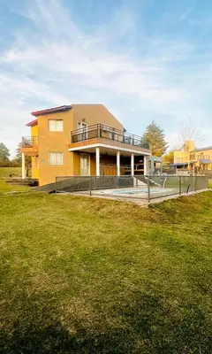 a large yellow house with a large lawn in front of it at MIRADOR Rest House in Bialet Massé