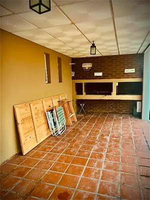 an empty room with wooden doors and a brick wall at MIRADOR Rest House in Bialet Massé