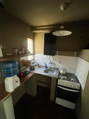 a small kitchen with a stove and a sink at Moderno PH, céntrico y económico, muy comodo, cocina, wifi, cochera techada privada in Cordoba