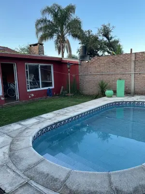 a swimming pool in a yard next to a house at Casa Alvarez in Villa Carlos Paz