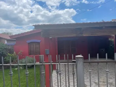 a red house with a fence in front of it at Casa Alvarez in Villa Carlos Paz
