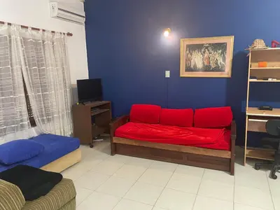 a living room with a red couch in a room at Casa Alvarez in Villa Carlos Paz