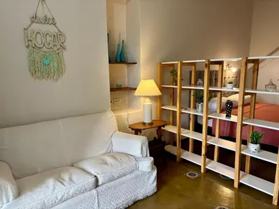 a living room with a white couch and shelves at Posada del Valle solo adultos in Merlo