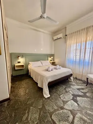 a bedroom with a bed and a ceiling fan at Posada del Valle solo adultos in Merlo