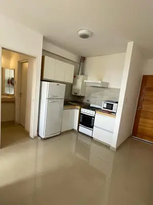 a kitchen with white cabinets and a white refrigerator at Sunset SORRENTO con Cochera in Villa Carlos Paz