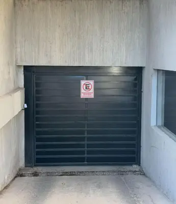 a garage door with a no parking sign on it at Sunset SORRENTO con Cochera in Villa Carlos Paz