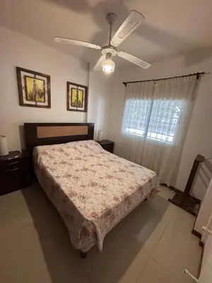 a bedroom with a bed and a ceiling fan at Sunset SORRENTO con Cochera in Villa Carlos Paz