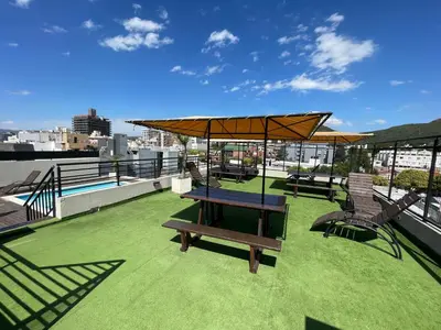 a patio with a table and chairs on a roof at Sunset SORRENTO con Cochera in Villa Carlos Paz