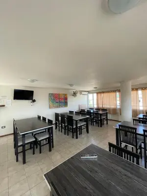 a dining room with tables and chairs and a flat screen tv at Sunset SORRENTO con Cochera in Villa Carlos Paz