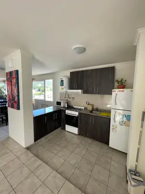 a kitchen with wooden cabinets and a white refrigerator at Sunset SORRENTO con Cochera in Villa Carlos Paz