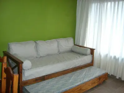 a couch in a room with a green wall at Tica Masu in Villa Carlos Paz