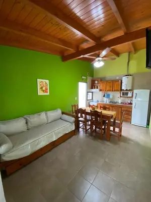 a living room with a couch and a table and a kitchen at Tica Masu in Villa Carlos Paz