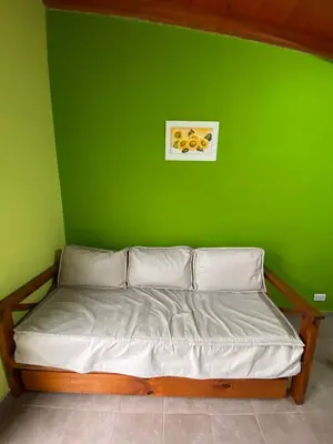 a green wall with a bed in a bedroom at Tica Masu in Villa Carlos Paz
