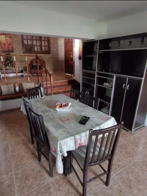 a dining room with a table and chairs and a kitchen at Lomas De Piquillin in Villa Carlos Paz
