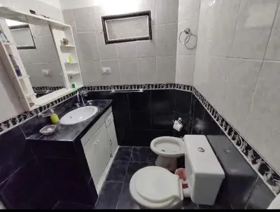 a bathroom with a white toilet and a sink at Lomas De Piquillin in Villa Carlos Paz