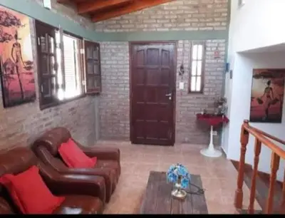a living room with a couch and a door at Lomas De Piquillin in Villa Carlos Paz