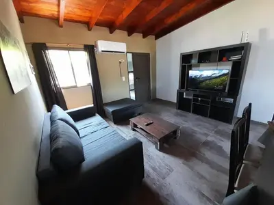 a living room with a couch and a tv at Lomas De Piquillin in Villa Carlos Paz